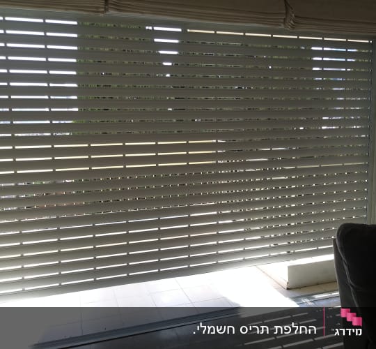 תריסי אלומיניום סגורים עם אור שמש חודר